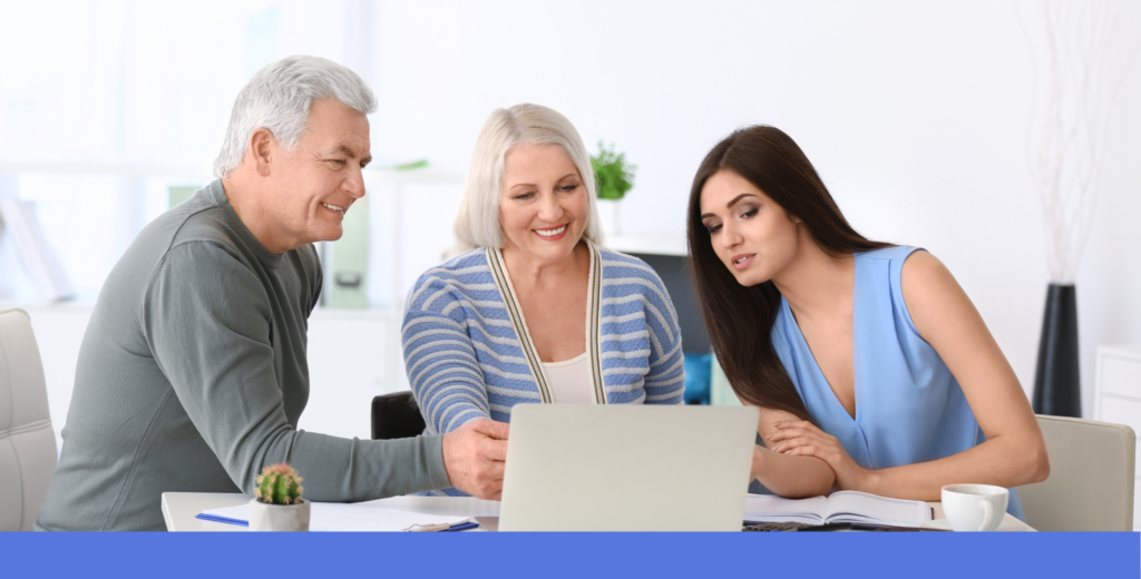 Retirement aged couple and their daughter look at a laptop to discuss future.